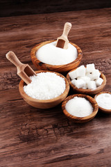 Sugar composition with white sugar in bowls on wooden board