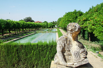 Statue and gardens with fountains of the Alcazar de los Reyes Cristianos in Cordoba, Andalusia