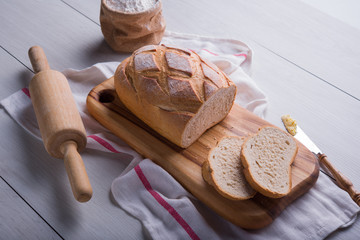 Freshly baked bread on wooden cutting board, Slice bread, wheat flour and cutting knife
