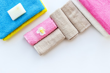 Preparing to take bath. Towels and soap on white background top view copyspace
