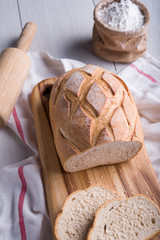 Freshly baked bread on wooden cutting board, Slice bread, wheat flour and cutting knife