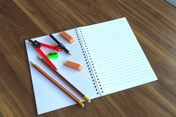 School Supplies. Standard sharpened pencil, Compass and Eraser on spiral bound notepad.