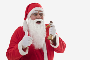 Front view of Santa Claus showing thumbs up while eating chocolate bar over white background 