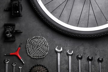 Bicycle parts and repair tools on gray background