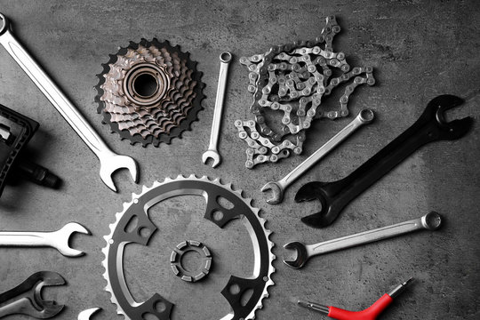 Fototapeta Bicycle parts and repair tools on gray background