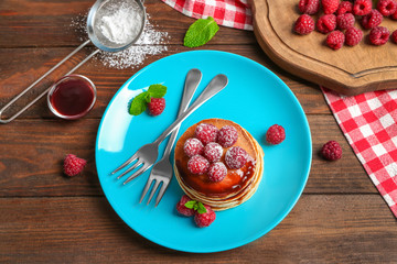 Plate with delicious pancakes on table