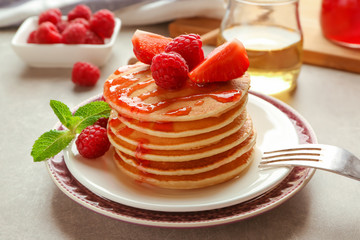 Plate with delicious pancakes on table
