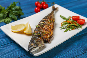 Grilled tasty fish on white plate with vegetables