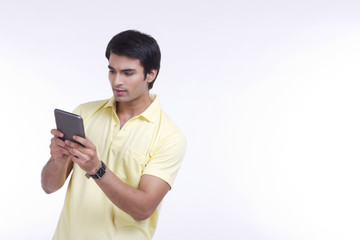 Fototapeta premium Handsome young man using tablet computer over white background