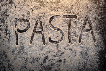 Text pasta on flour top view