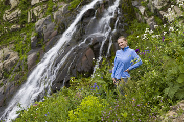 Naklejka na ściany i meble Young hiking woman at a mountain waterfall