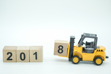 2018 New year concept. Close up of toy forklift truck machine with 2018 number wooden block toy.