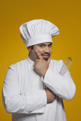 Portrait of chef holding wire whisk