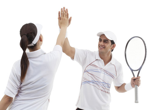 Tennis players doing high five isolated over white background