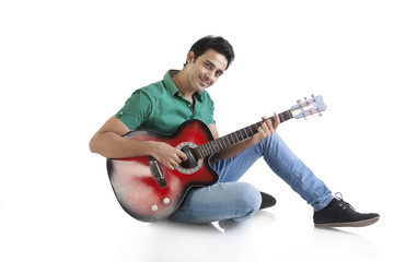Obraz premium Portrait of a young man playing a guitar