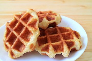 Plate of Belgian Waffles on White Plate Served on Wooden Table 