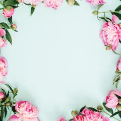 Keuken foto achterwand Bloemen Frame wreath of pink peony flowers, branches, leaves and petals with space for text on blue background. Flat lay, top view. Peony flower texture.