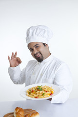 Portrait of chef with plate of pasta