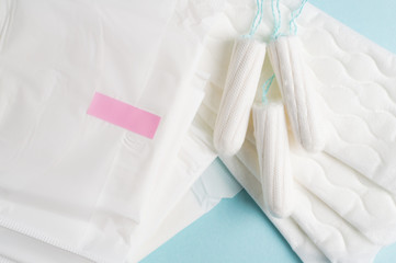 Menstrual tampons and pads on a blue background. Menstruation time. Hygiene and protection