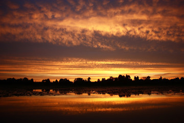 Sunset in yellow tones./At sunset of a cloud and lake water were partially painted in yellow tone.