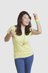 Portrait of happy young woman in casuals wearing Indian tricolor bangles over white background 