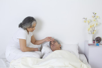 Obraz na płótnie Canvas Wife checking husband's fever
