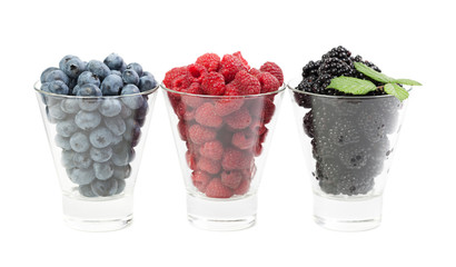 Berry raspberries blackberry blueberries in glass cups isolated on white background