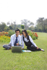 Businessman and businesswoman working in a park