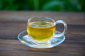 Crystal cup with green tea on table