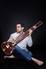 Obraz premium Young man playing the sitar