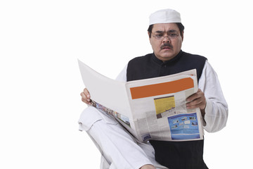 Politician reading newspaper with shocked expression 