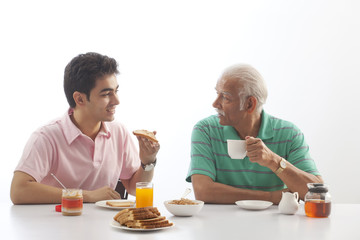 Fototapeta na wymiar Grandfather and grandson eating breakfast