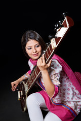 Obraz na płótnie Canvas Young woman playing the sitar