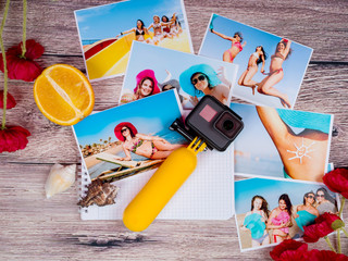 A lot of pictures of young girls in a swimsuit and hats on the sea and an action camera gopro on a wooden table.