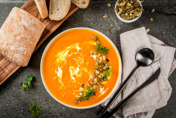 Traditional fall and winter dishes, hot and spicy pumpkin  soup with pumpkin seeds, cream and...