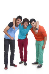 Obraz premium Full length of three male friends smiling together over white background