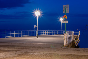 Small pier in Gdynia at Feliks Nowowiejski boulevard on Baltic sea at night. - obrazy, fototapety, plakaty