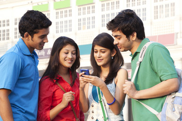 Friends reading text message on mobile phone 