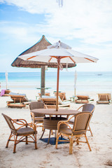 Summer empty open air table on beach at sunset