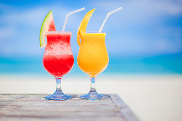 Two cocktails of watermelon and mango on background of stunning turquoise sea
