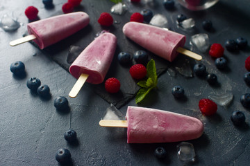 Homemade frozen fruit popsicles with fresh natural raspberry and blueberry, tasty ice pops, summer food concept, selective focus