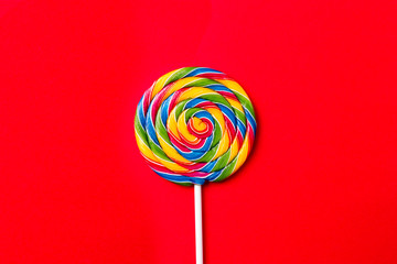 Tasty appetizing Party Accessory Sweet Swirl Candy Lollypop on Red Background Top View