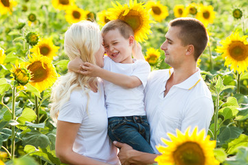 A happy family plays in sunflowers.