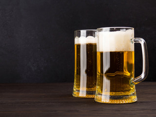 Two glasses of lager served on old wooden planks, copyspace for text