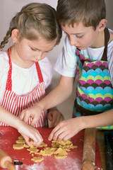 Boy and girl making Christmas cakes at home 