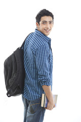 Portrait of aspiring young man with book and bag over white background 