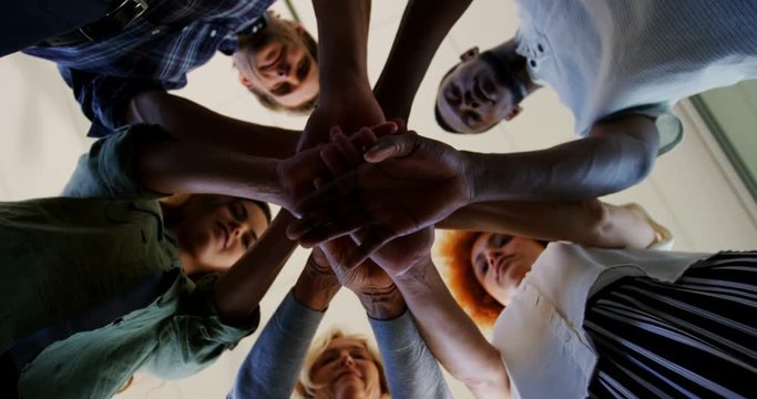 Team of African American and mixed-race executives forming hand stack