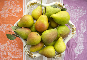 Pears stacked in beautiful dishes on a summer background
