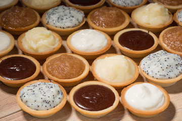 Tartlets on the table, assortment with different creams