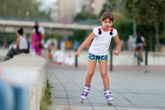 Little girl riding roller skates on the street